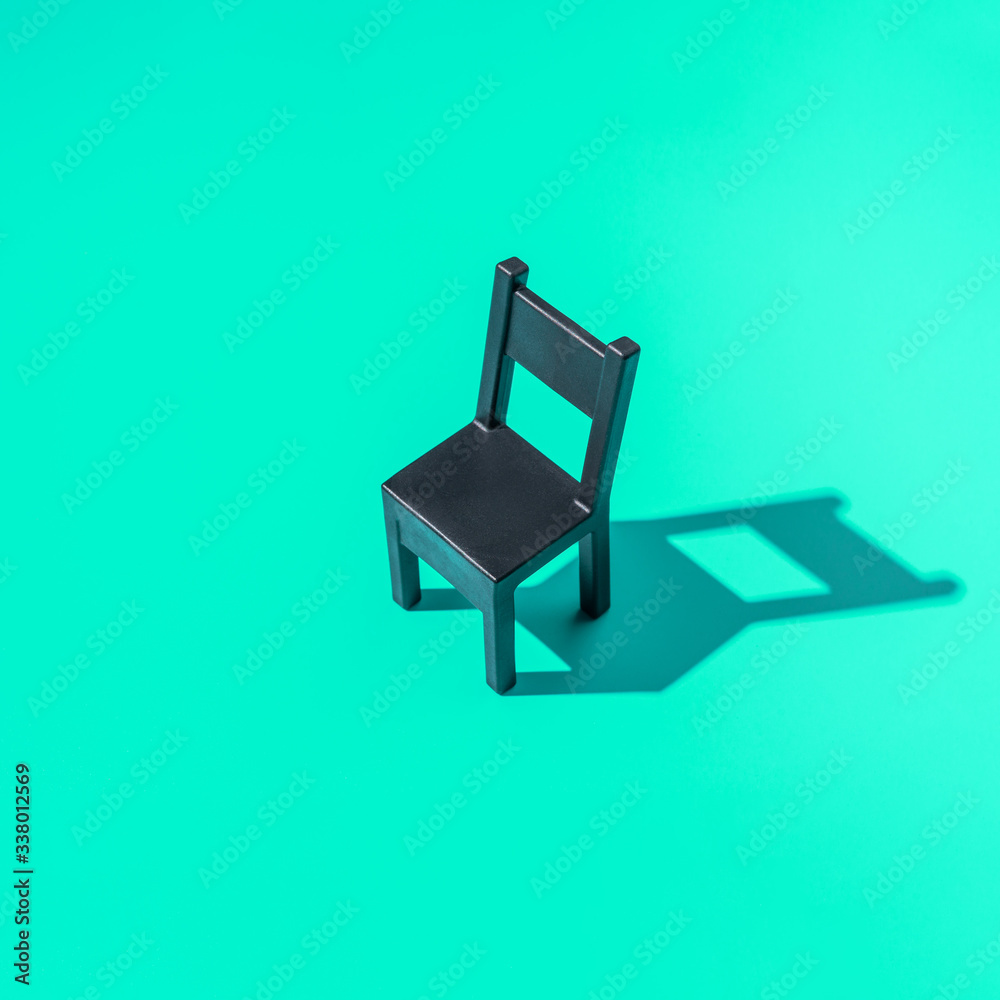 Concept Secretary`s Day, black chair on a mint background, symbol of work in the office, hard light, minimalism. Concept Secretary`s Day, black chair on a mint background, symbol of work in the office, hard light, minimalism.
