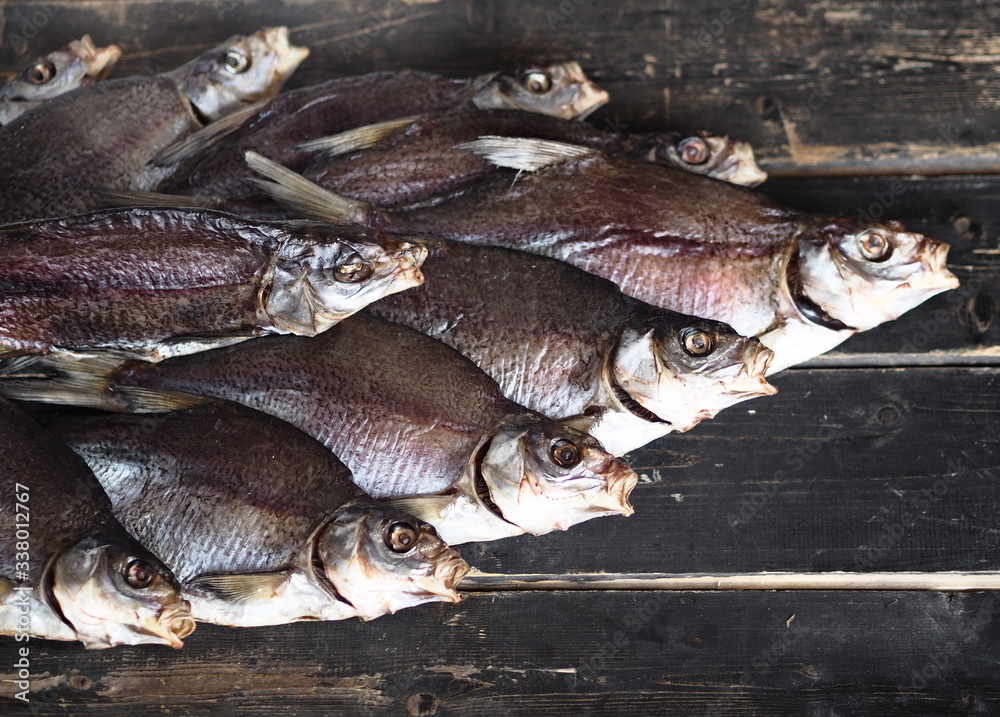 A lot of air-dried, salty freshwater bream on a dark wooden ancient background.River fish.