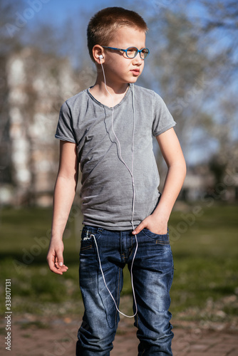 Cute little boy in gray T-shirt posing. Portrait of fashionable male child. Concept of children style and fashion.