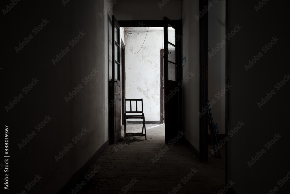 Chair at the end of a dark corridor