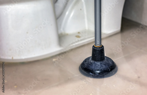 Obraz na plátne Dirty Plunger Soaked in a Pool of Overflown Toilet Water.