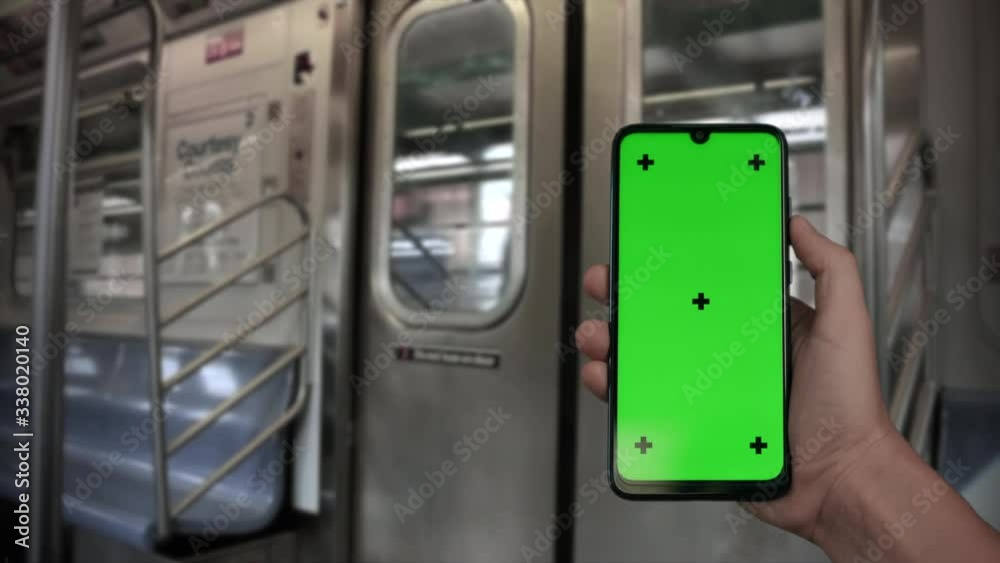 NEW_Hand holding Chroma Key Green Screen smartphone in front of door riding subway train