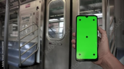 NEW_Hand holding Chroma Key Green Screen smartphone in front of door riding subway train