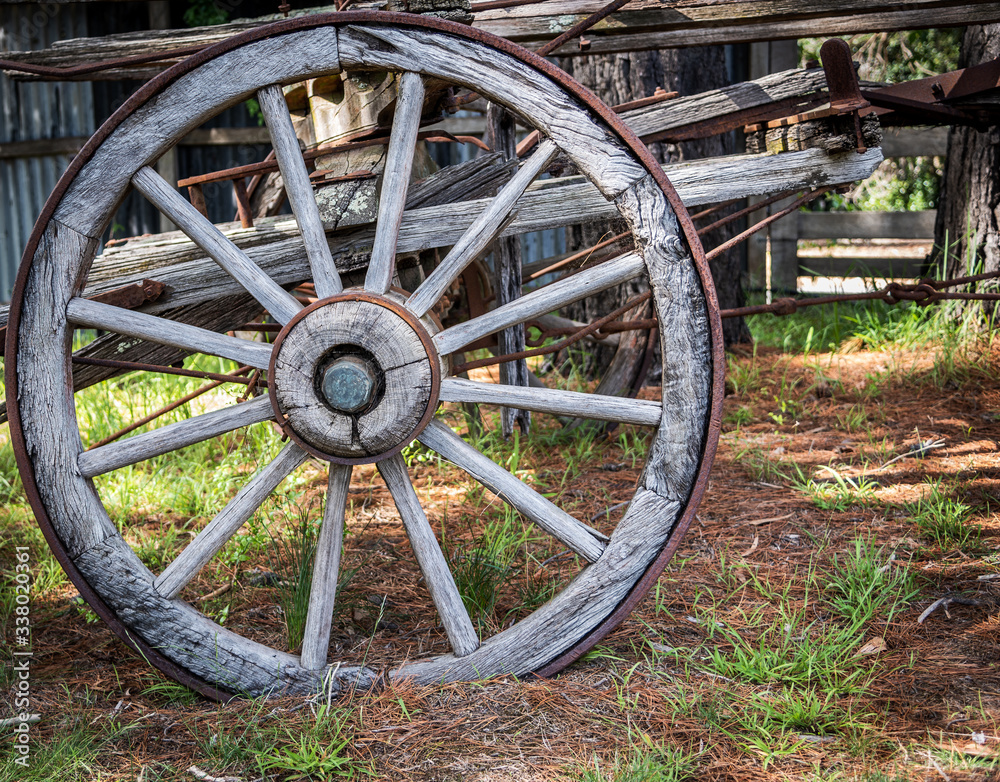 An old wooden rusty waggon wheel in a rural setting