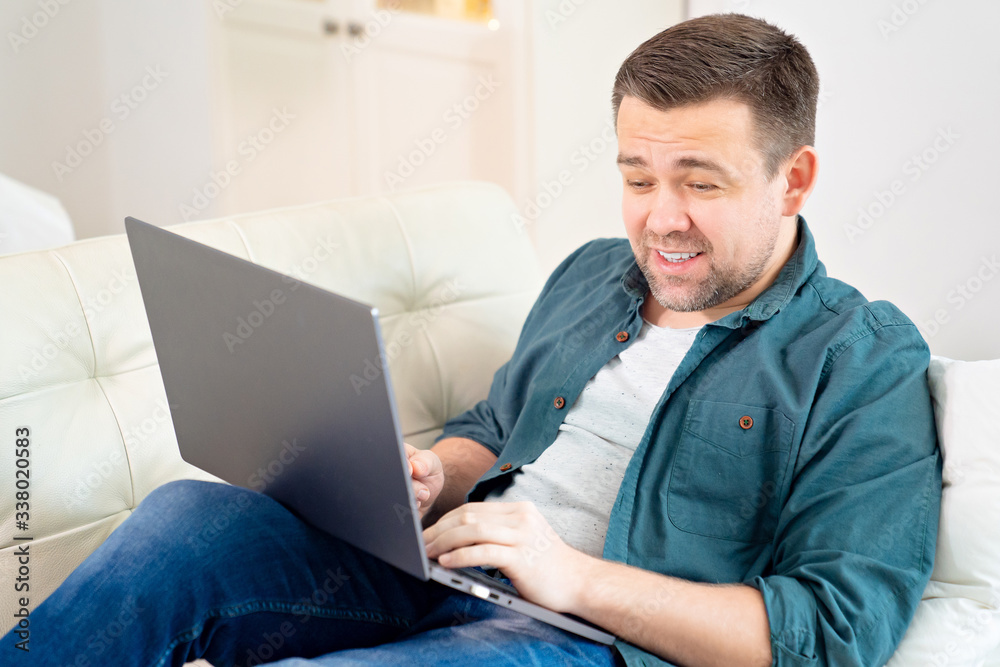 man freelancer working online lying on the couch.
