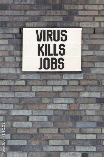 Virus Kills Jobs words in light box letters, corona virus pandemic buzwword headline