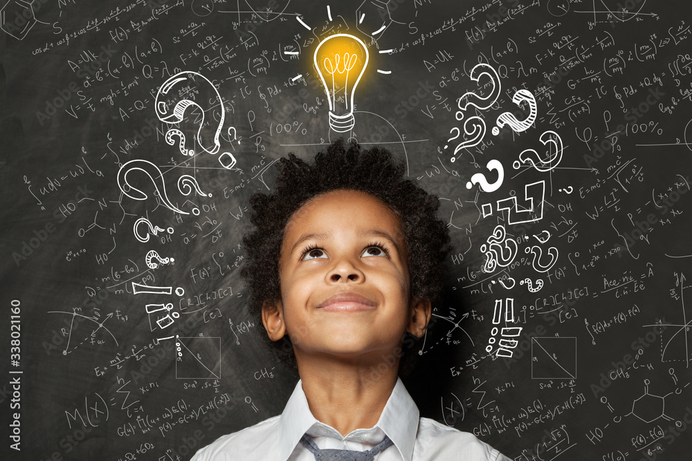 Smart kid with lightbulb. Brainstorming and idea concept. Little cute student boy on chalkboard background - obrazy, fototapety, plakaty 