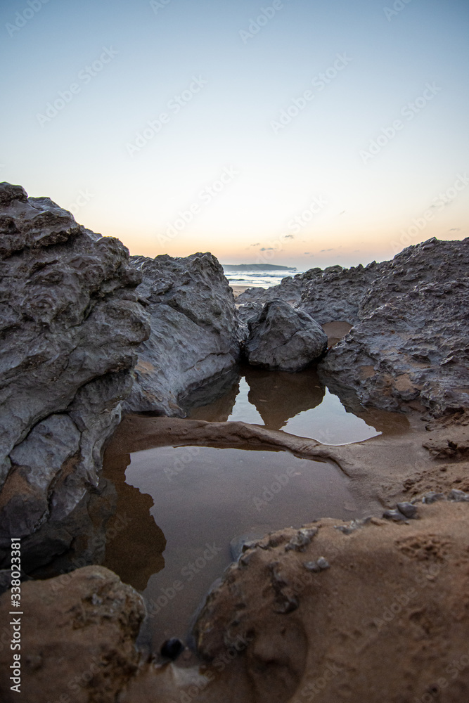 Obraz premium sunset near the sea between the rocks at the beach