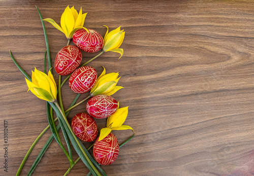 Hand painted traditional red Easter eggs with Hungarian motives and yellow tulips, top view