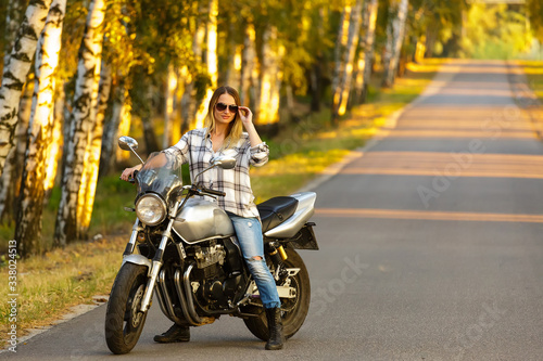 Sexy girl on a classic motorcycle. © Sergey Shmakov