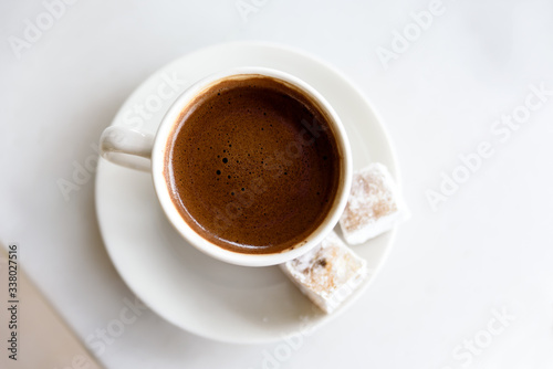 Cup of Greek - Turkish coffee isolated on white background with sweety delight