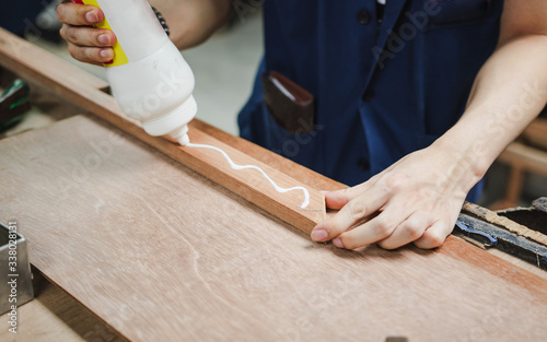 Worker use glue to stick pieces of wood together photo