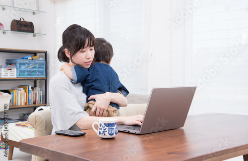 2歳の男の子とパソコンをする母