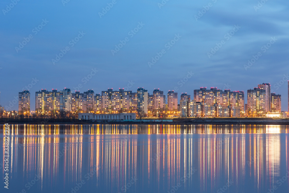 Night lights of the metropolis are reflected in the water surface of the river