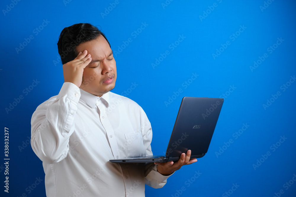 Portrait of young Asian businessman looked tired and suffer from stiffed headache Portrait of young Asian businessman looked tired and suffer from stiffed headache