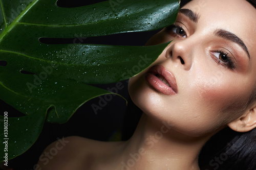Фотография beautiful wet girl in palms. Beautiful woman with Make-up