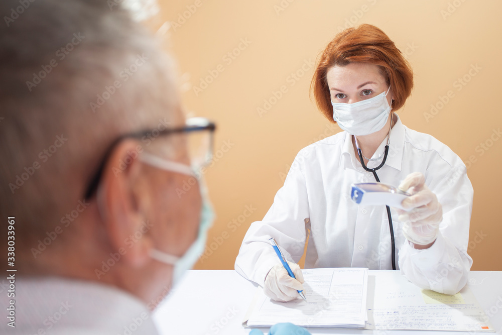 coronavirus pandemic. Doctors in medical masks and gloves measure the temperature with a thermometer coronavirus pandemic. Doctors in medical masks and gloves measure the temperature with a thermometer