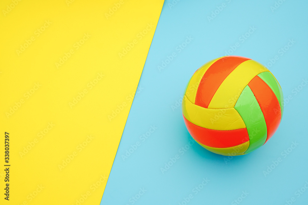 Bright multi-colored volleyball ball on yellow blue background with copy space. Top view Flat lay Minimal style Template for card, design Bright multi-colored volleyball ball on yellow blue background with copy space. Top view Flat lay Minimal style Template for card, design