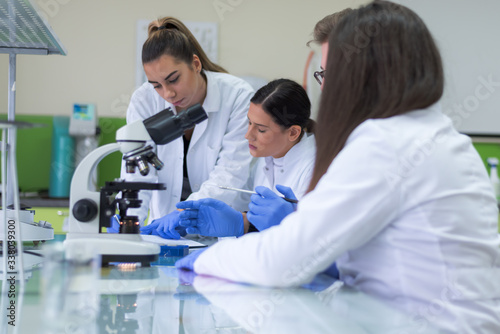 Group of Laboratory scientists working at lab with test tubes, test or research in clinical laboratory.Science, chemistry, biology, medicine and people concept.
