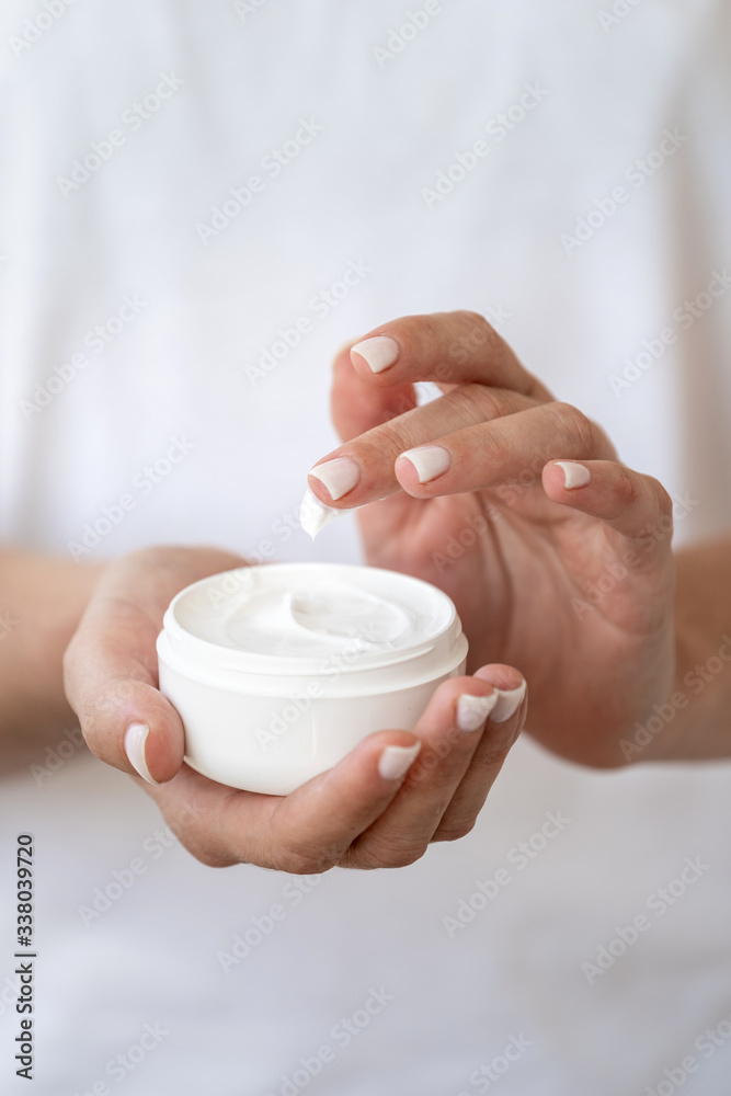 Woman holding container with soft cream in hands Woman holding container with soft cream in hands