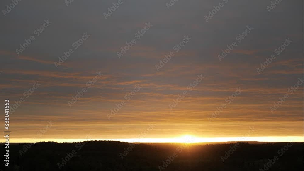 Aerial panoramic time lapse of a picturesque red and pink veil of clouds moving over the horizon during twilight. Epic sunset in the night sky in 4k