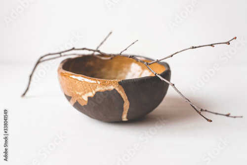 Handmade ceramics in the style of wabi sabi. Brown clay bowl with an abstract pattern. photo