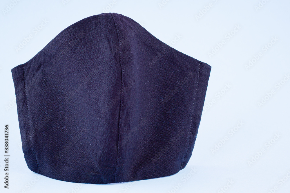 Protective mask on a pastel background. Anti-virus mask made of cotton. Black face mask during a virus COVID-19. Handmade face mask on blue background Protective mask on a pastel background. Anti-virus mask made of cotton. Black face mask during a virus COVID-19. Handmade face mask on blue background