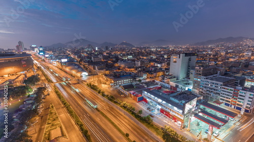 Aerial view of Via Expresa highway and metropolitan bus with traffic day to night timelapse. Lima, Peru © neiezhmakov