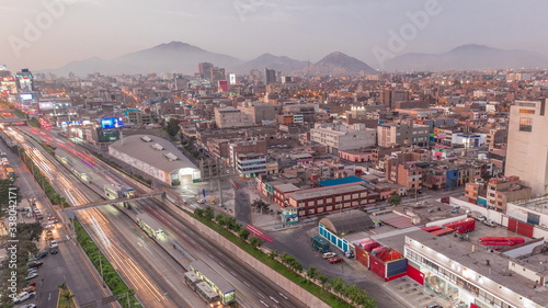 Aerial view of Via Expresa highway and metropolitan bus with traffic day to night timelapse. Lima, Peru