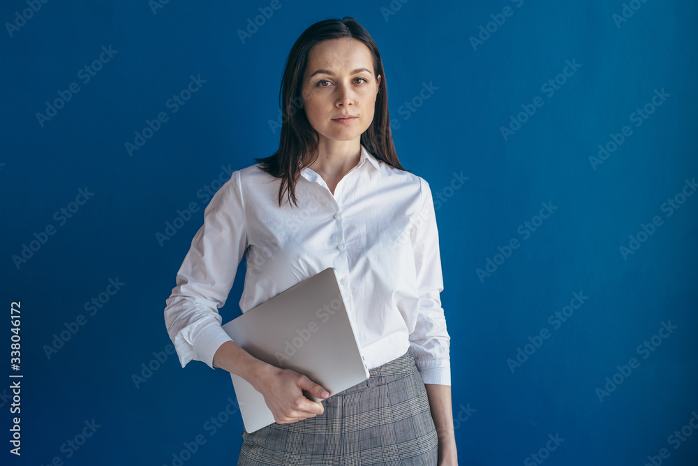 Portrait of young serious business woman with laptop looking at camera. Portrait of young serious business woman with laptop looking at camera.
