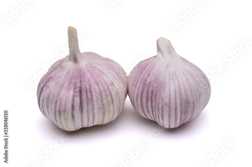 Two garlic close-up on a white background with a shadow