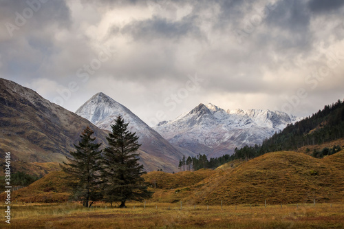 Autumn landscape in Highlands  Scotland  United Kingdom. Beautiful mountains with snow in background.