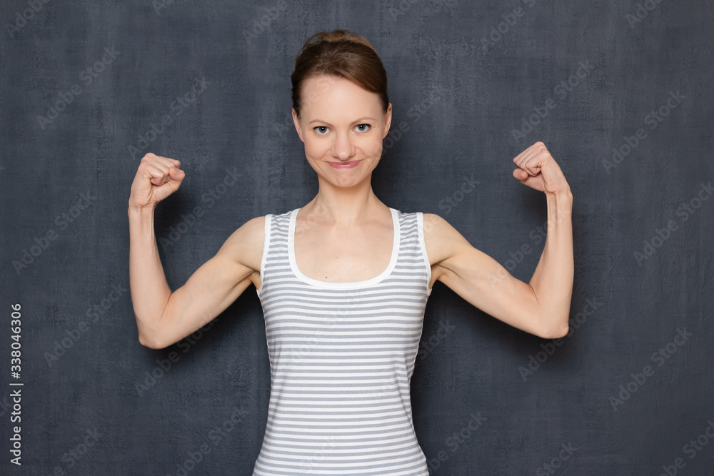 Portrait of happy young woman raising fists up, rejoicing at victory Portrait of happy young woman raising fists up, rejoicing at victory