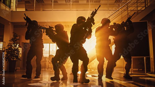 Tablou pe pânză Masked Fireteam of Armed SWAT Police Officers Storm a Sunny Seized Office Building with Desks and Computers