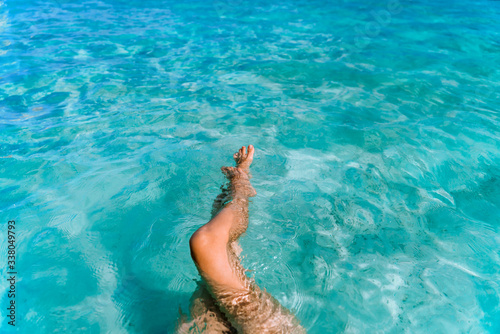 Photo of sexy female legs in clear turquoise sea water. Beautiful young girl bathing © Konstantin