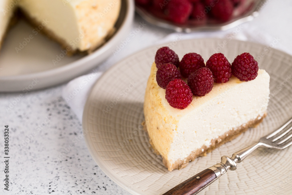 Slice Of Classical New York Cheesecake with raspberries On White Plate. Closeup View. Home bakery concept