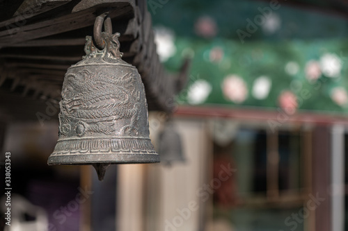 a dragon-patterned bell hanging inside a temple.