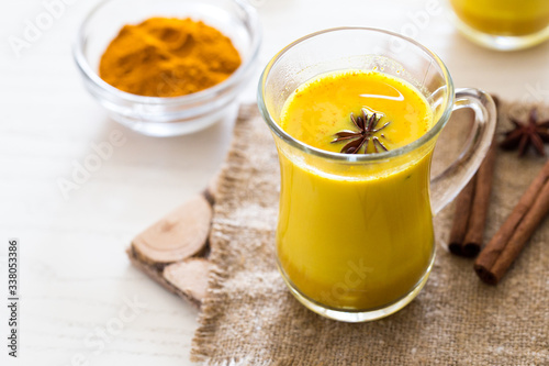 Turmeric tea drinks with milk and honey for beauty and health. Spicy healthy Haldi