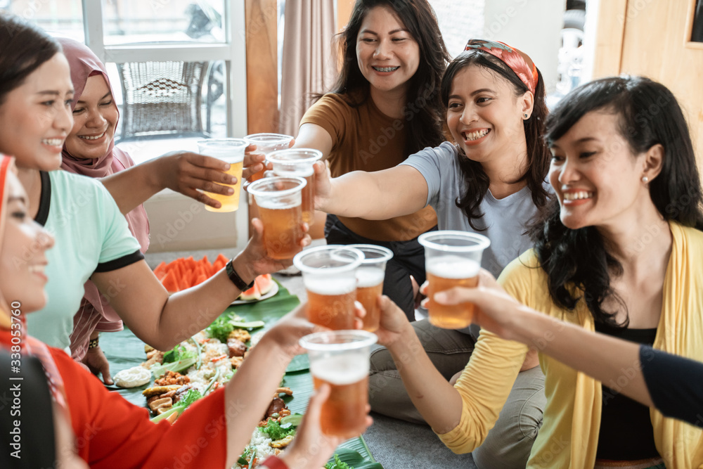 Obraz premium tea time with friend during lunch. muslim asian woman with friends together. toast their glass