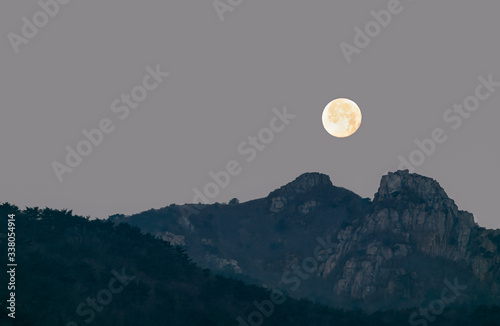 A scene where a full moon rises to a famous mountain in Busan, Korea. photo