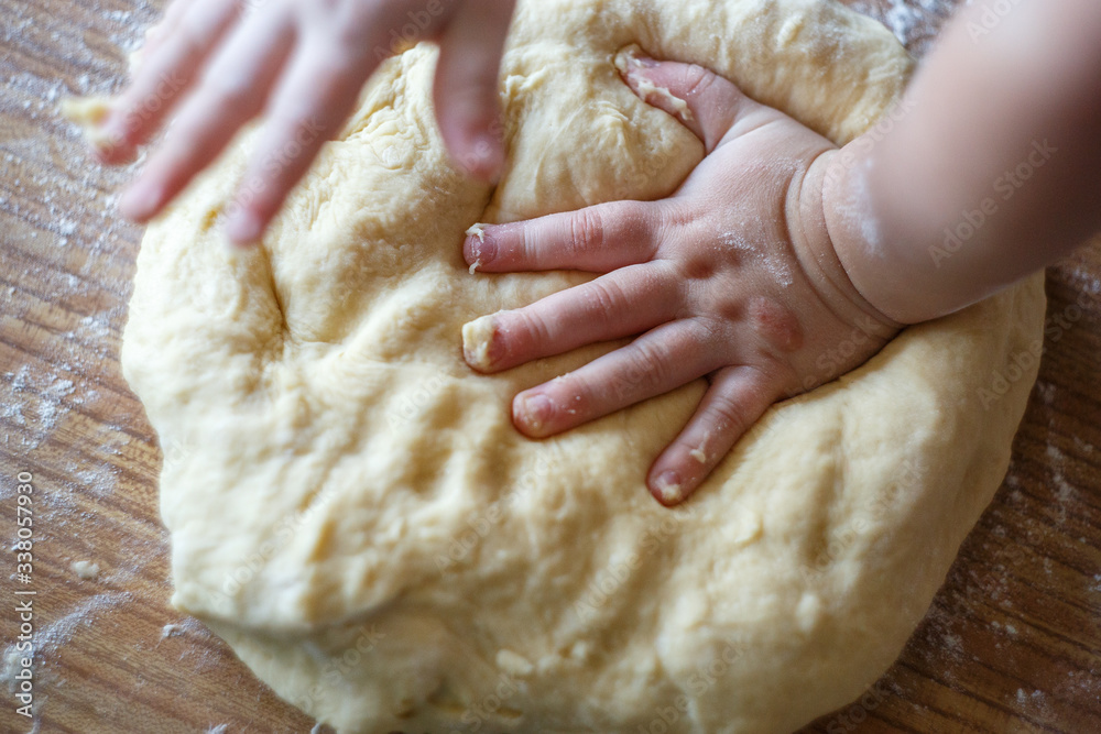 Child's hands knead yeast dough closeup Child's hands knead yeast dough closeup