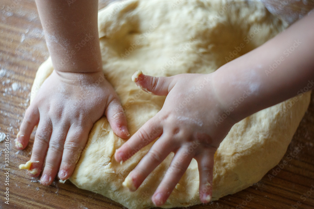 Child's hands knead yeast dough closeup Child's hands knead yeast dough closeup