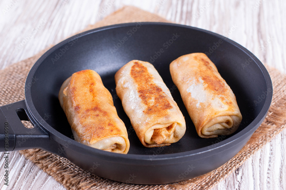 Frying pan with fried pancake roll Frying pan with fried pancake roll