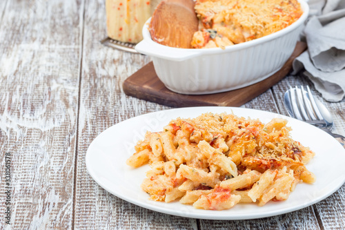 Spicy tomato jalapeno mac and cheese with mini penne pasta, on plate, horizontal, copy space photo