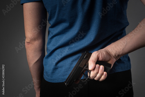 a man in a blue T-shirt pulls a gun behind his back