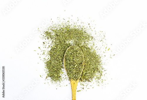 green mint leaves powder with wooden spoon on white background 
