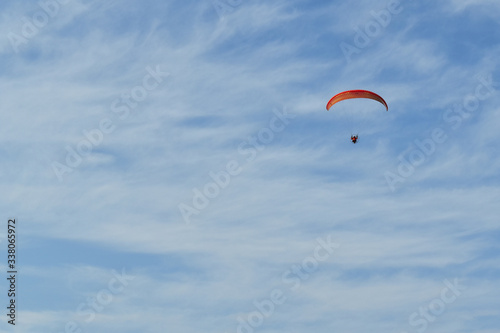Blue cloudy sky with a paraglider