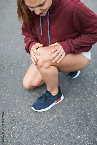 Detail of female athlete suffering from running knee painful injury.