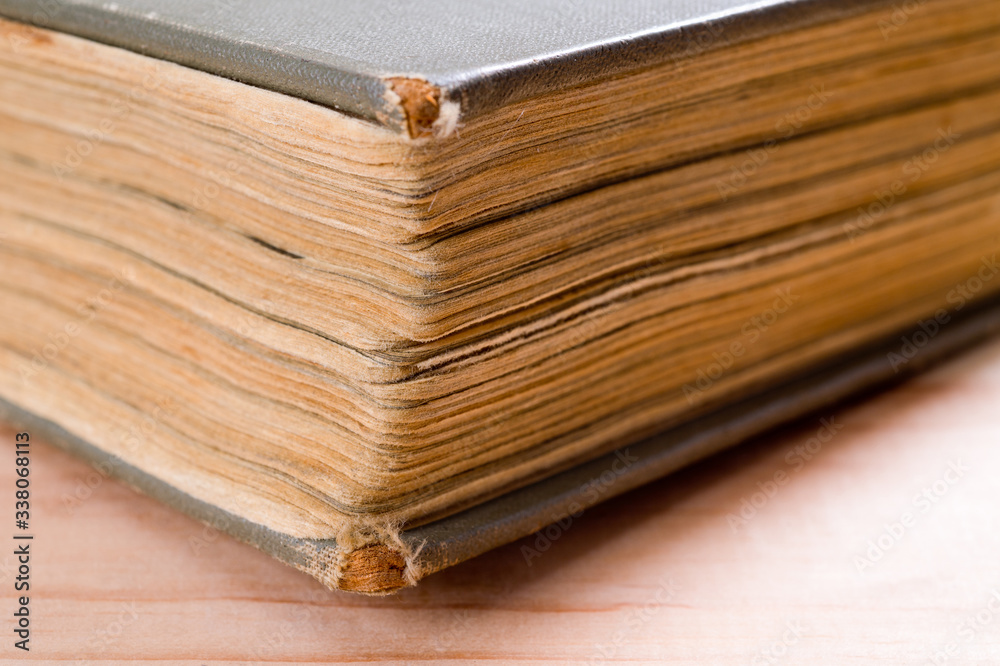 An old book with yellowed pages and a battered cover. Background for knowledge and history.