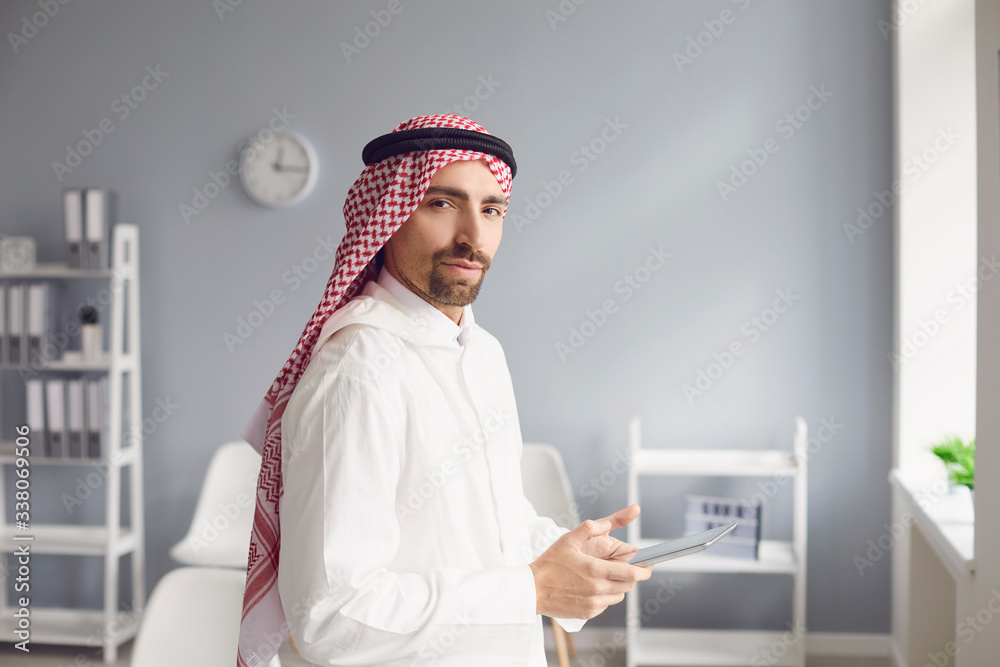 Pensive serious arabic man looks in a white office